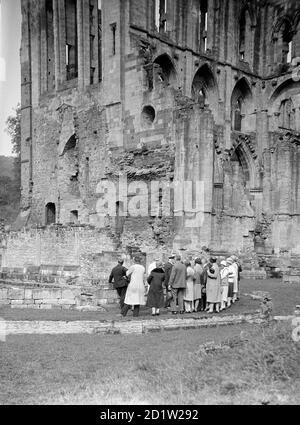 Un gruppo di visitatori che guardano il lato sud dell'abbazia di Rievaulx, Rievaulx, North Yorkshire, Regno Unito. Foto Stock