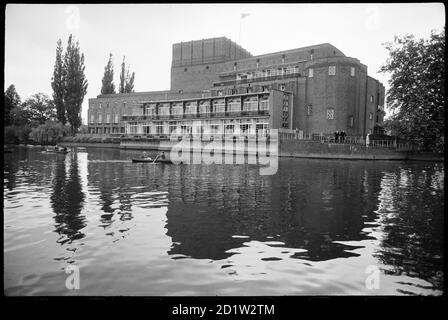 Vista esterna del fronte ovest del Royal Shakespeare Theatre, che si affaccia sul fiume Avon, con la facciata terrazzata, la torre poligonale a sinistra, e la parete cieca sull'estrema destra, la parte di schermatura dell'edificio vittoriano, Stratford-upon-Avon, West Midlands, UK. Foto Stock