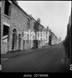 Vista verso est lungo le case a schiera derelict di Bedford Street con il muro di confine delle opere di Bedford all'estrema sinistra e la torre della chiesa di San Marco in lontananza. Foto Stock