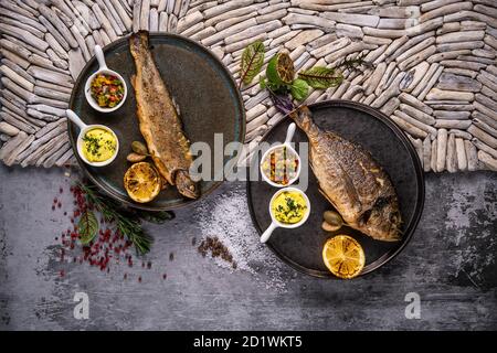 Set di due piatti di pesce con verdure su scrivanie di legno. Foto Stock