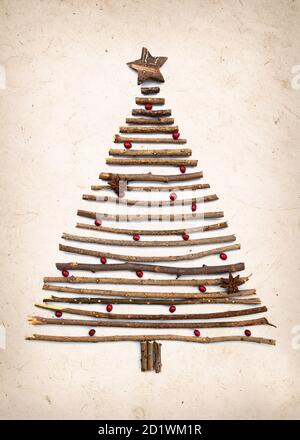 Albero di Natale rustico e creativo fatto a mano con rami di legno e rosso bacche Foto Stock