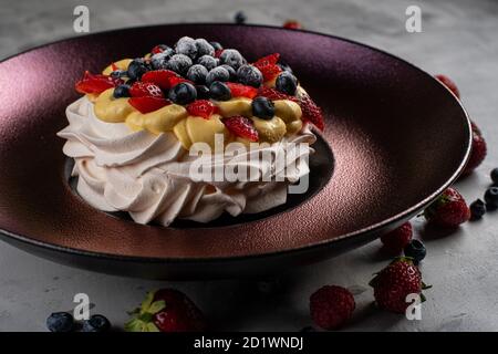 Splendido dessert alla torta Pavlova con meringa e frutta fresca sfondo bianco Foto Stock