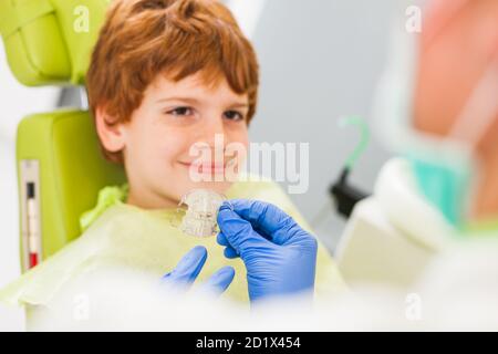 Dentista è insegnamento little boy circa le bretelle. Foto Stock