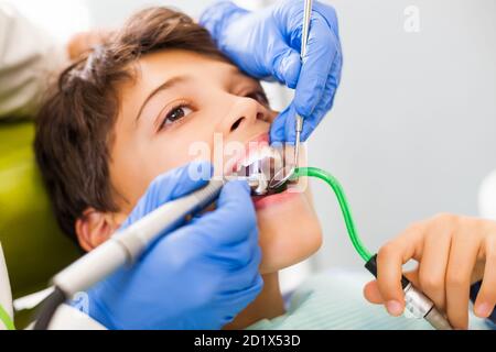 Dentista sta riparando i denti di un ragazzo. Foto Stock