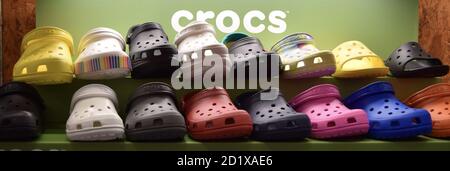 FRESNO, STATI UNITI - Set 01, 2020: Una foto Bright diversi colori di Croc Shoes in negozio shelfwith CROCS in bianco su sfondo verde Foto Stock