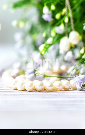 Bella collana di perle bianche con fiori bianchi. Foto Stock