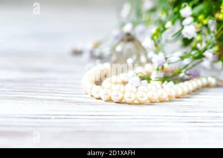 Bella collana di perle bianche con fiori bianchi. Foto Stock