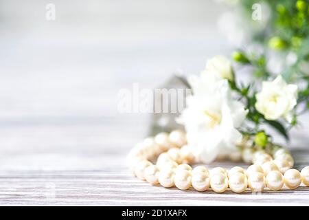 Bella collana di perle bianche con fiori bianchi. Foto Stock