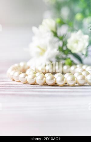 Bella collana di perle bianche con fiori bianchi. Foto Stock