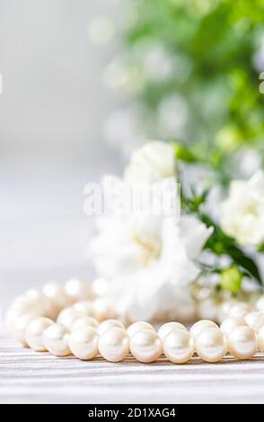 Bella collana di perle bianche con fiori bianchi. Foto Stock