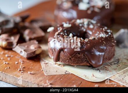 Ciambelle di cioccolato con glassa al cioccolato, noci. Giornata nazionale delle ciambelle. Cottura fatta in casa. Foto Stock
