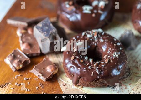Ciambelle di cioccolato con glassa al cioccolato, noci. Giornata nazionale delle ciambelle. Cottura fatta in casa. Foto Stock