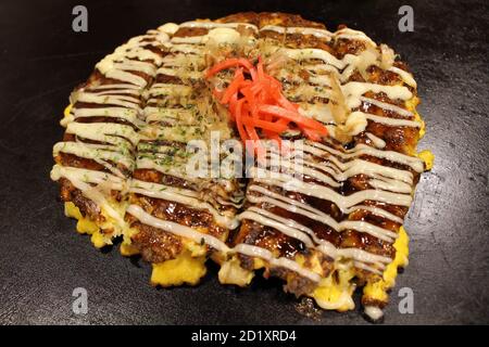 La preparazione di Okonomiyaki, pizza giapponese, viene cucinata sulla padella o sul tepan. Foto Stock