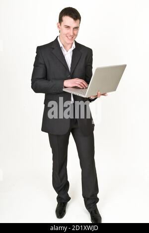 Giovane uomo in tuta da lavoro con computer portatile Foto Stock