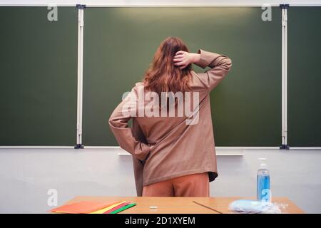 L'insegnante è in dubbio sulla lavagna, spazio di copia Foto Stock