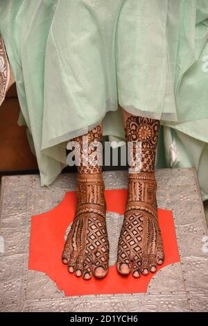 Cerimonia Mehendi con tatuaggi di hennè a piedi. Cerimonia Mehndi che si terrà la notte prima del matrimonio come un modo di augurare alla sposa buona salute e pro Foto Stock