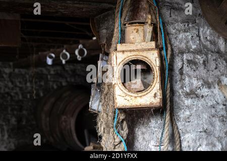 Vecchia lanterna arrugginita appesa in un vecchio fienile in una fattoria a Somerset, Regno Unito Foto Stock