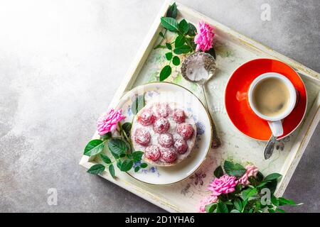 Colazione romantica a letto, tazza di caffè espresso con , vassoio con torta di lamponi e rosa rosa. Buon concetto di mattina. Foto Stock