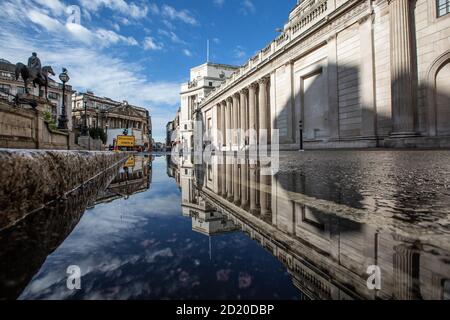 Bank of England, e Royal Exchange si sono riflesse in un pozze dopo le forti tempeste di pioggia nella City of London, Threadneedle Street, Inghilterra, Regno Unito Foto Stock