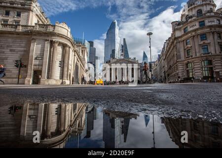 Bank of England, e Royal Exchange si sono riflesse in un pozze dopo le forti tempeste di pioggia nella City of London, Threadneedle Street, Inghilterra, Regno Unito Foto Stock