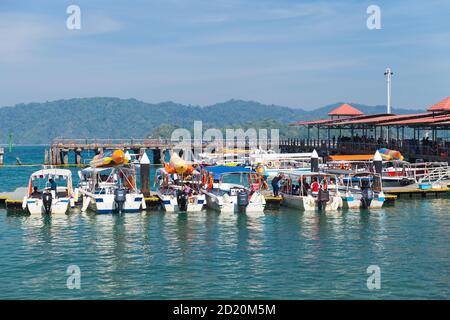 Kota Kinabalu, Malesia - 17 marzo 2019: Piccoli motoscafi con passeggeri sono ormeggiati vicino al terminal dei traghetti di Jesselton Point in giornata di sole Foto Stock