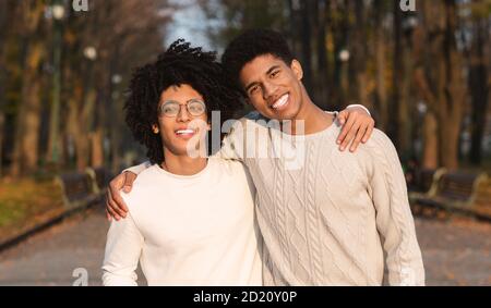 Due ragazzi africani che abbracciano lo sfondo del parco Foto Stock