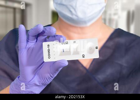 La mano di un medico o di un tecnico di laboratorio mostra un test COVID-19 di laboratorio rapido per rilevare anticorpi IgM e IgG contro il nuovo coronavirus, SARS-COV-2 WIT Foto Stock