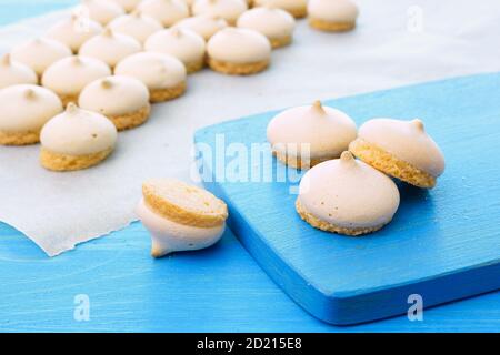 Meringa torta d'aria. Biscotti di meringa appena sfornati su un tavolo blu. Primo piano. Foto Stock