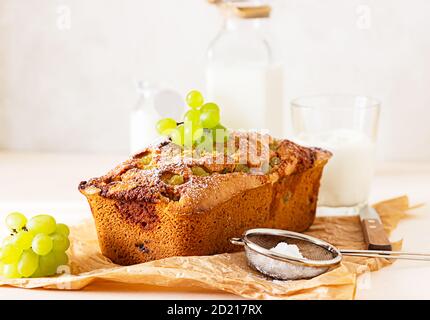 Deliziosa torta fatta in casa con timo e zucchero in polvere su carta pergamena. Sfondo di pietra chiaro. Foto Stock