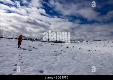 Solitaria escursionista femminile, e neve all'inizio dell'inverno presso l'Plateau de Beille, zona sciistica nordica, Les Cabannes, Ariege, Francia Foto Stock