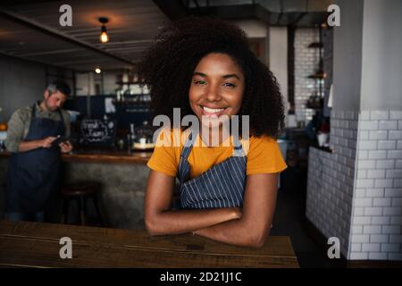 Bella donna afroamericana sorridente mentre si inchinò in un elegante bar. Foto Stock