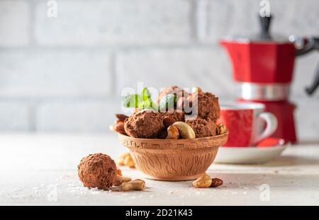 Deliziose palle energetiche fatte in casa con albicocche secche, datteri, prugne, noci, mandorle e anacardi in cocco e cacao. Foto Stock