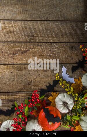 Concetto felice di festa di Halloween. Decorazioni di Halloween, pipistrelli, fantasmi, zucche, su sfondo di legno. Halloween party biglietto d'auguri mockup con copia s. Foto Stock