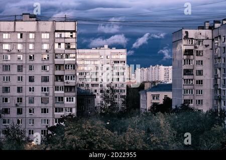 Edifici alti e cupi della città sullo sfondo di un cielo nuvoloso. Paesaggio urbano serale in un'area da sogno. Foto Stock