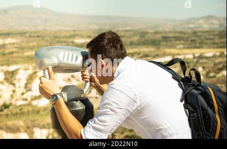 Uomo che guarda attraverso uno spettatore esterno orizzontale al punto di osservazione in Turchia Foto Stock