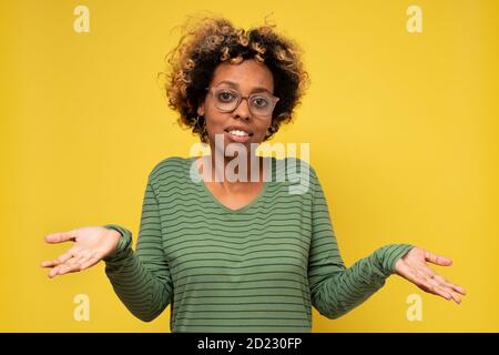 Bella donna africana che si infrangono le spalle avendo dubbi. Foto Stock