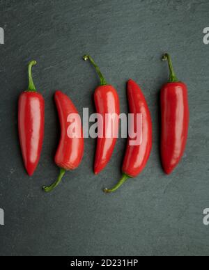 Peperoni in chili su sfondo naturale di ardesia Foto Stock