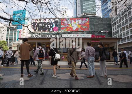 Tokyo, Giappone. 06 ottobre 2020. Le persone che indossano maschere facciali camminano davanti ad un centro di informazioni turistiche aperto di recente ‘Shibu Hachi Box' a Shibuya, Tokyo. E' stato aperto il 1 Ottobre 2020 e sostituito l'iconico vagone ferroviario verde d'epoca che ha ospitato il centro per molti anni. Credit: SOPA Images Limited/Alamy Live News Foto Stock