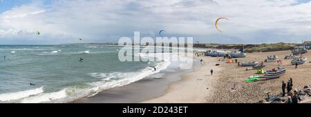 Nørre Vorupør, Danimarca - 5 settembre 2020: Vista panoramica sulla spiaggia del Mare del Nord frequentata da kite surfisti e spettatori in una giornata molto ventosa Foto Stock