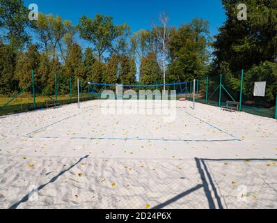 Campo da Beach volley chiuso nella stagione autunnale. Tempo autunnale e foglie cadute su sabbia bianca del parco giochi. Foto Stock