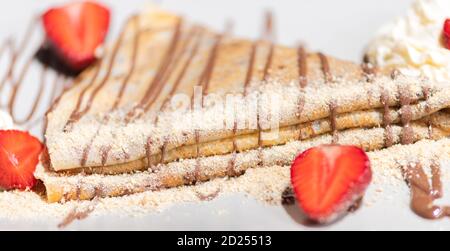 Deliziosa frittella con fragola e crema sul piatto Foto Stock