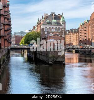 Il ristorante Wasserschloss è l'iconico edificio centrale costruito su un'isola nel quartiere dei magazzini Speicherstadt ad Amburgo. Costruito dal 1883 al 1927. Foto Stock
