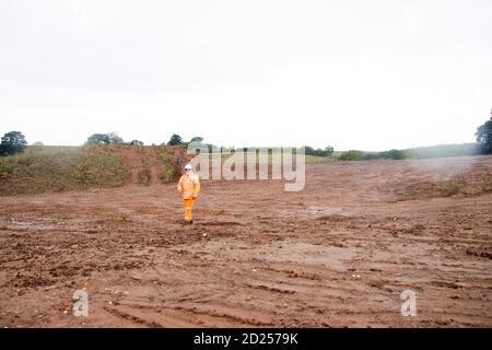 Warwickshire, Regno Unito. 05 ottobre 2020. Warwickshire, Inghilterra, Regno Unito. Un uomo di sicurezza HS2 cammina attraverso la terra desolata seguendo la distanza boschiva intorno all'antico bosco di Cubbington per far posto alla linea ferroviaria ad alta velocità HS2 05 ottobre 2020. Credit: Denise Laura Baker/Alamy Live News Foto Stock