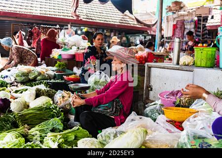 KAMPOT, CAMBOGIA - Agosto 07, 2019: Una donna commerciante che vende verdure e frutta al COMMERCIANTE a donna che vende verdure e frutta al Kampot fresco m Foto Stock