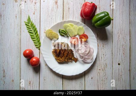 Tandoori pomfret, un piatto indiano servito in un piatto Foto Stock