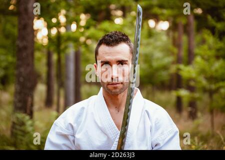 Uomo che pratica arti marziali in natura Foto Stock