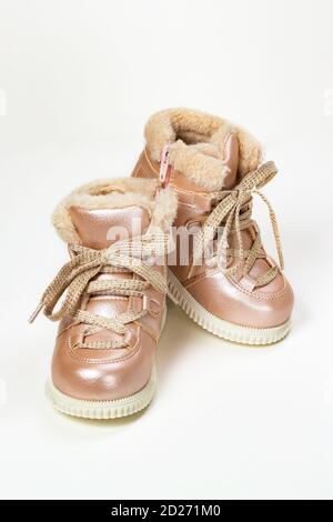 stivali invernali per bambini con lacci e pelliccia per ragazze, pelle rosa artificiale e lacci in lurex, foto verticale. Scarpe belle per un bambino, stivali caldi per Foto Stock