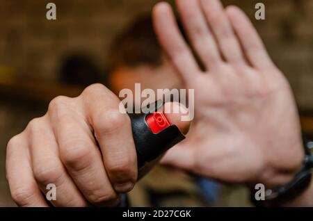 Uomo che tiene pepato spray per autodifesa primo piano Foto Stock