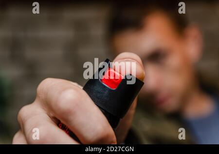 Uomo che tiene pepato spray per autodifesa primo piano Foto Stock