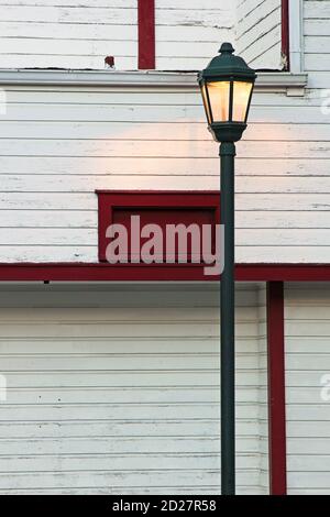 Lampione di strada contro un edificio con il colore rosso e bianco. Foto Stock